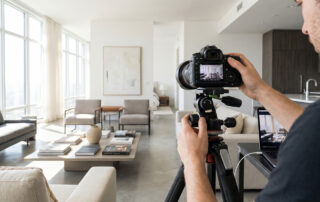 real estate photographer shooting modern apartment interior with professional camera setup